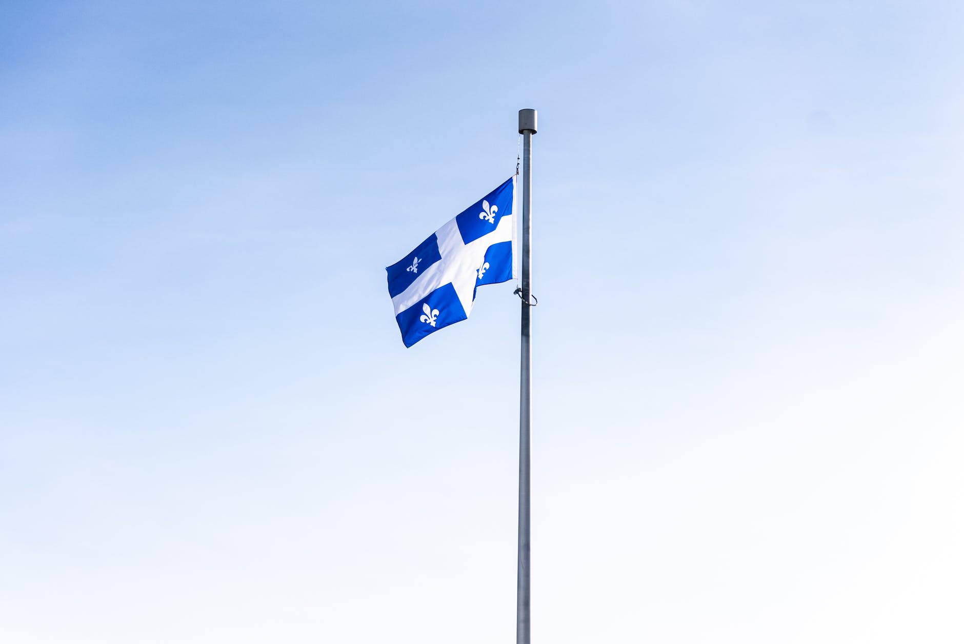 quebec flag on pole under white sky